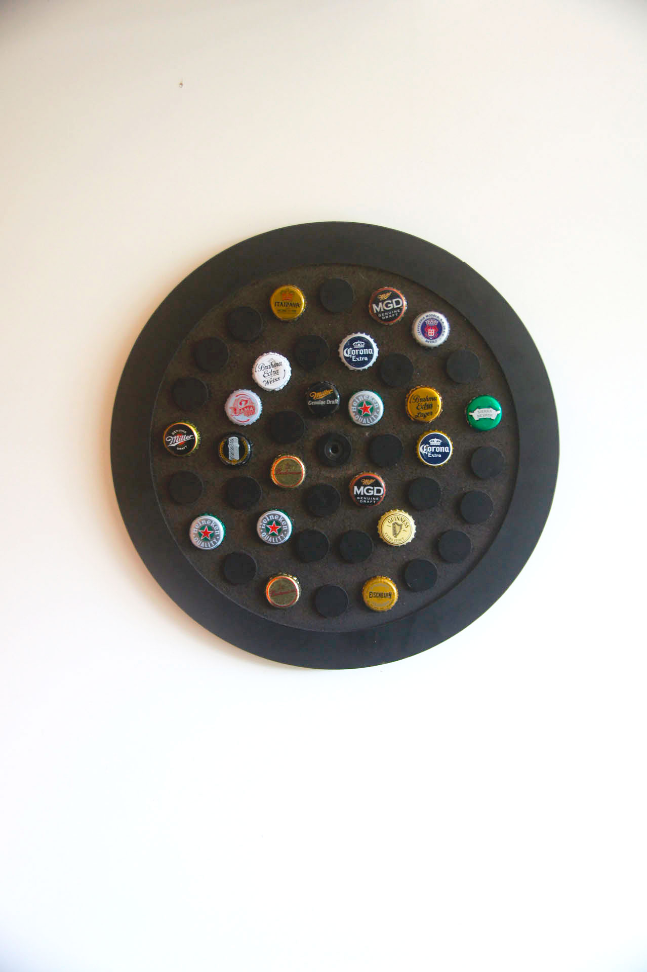 Display circular decorativo para 42 tampinhas em MDF usinado com acabamento laminado preto.